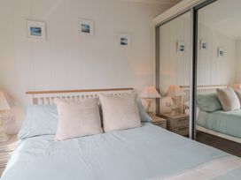 A bedroom with a bed and bedside tables at Hazelwood 3 in Pinewood Retreat in Rousdon near Lyme Regis
