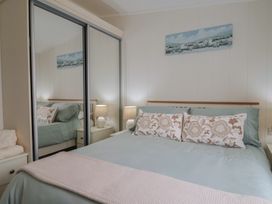 A bedroom with a bed and bedside tables at Hazelwood 3 Pinewood Retreat in Rousdon near Lyme Regis