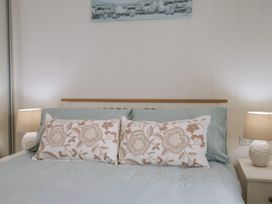 A bedroom with a bed and pillows at Hazelwood 3, Pinewood Retreat in Rousdon near Lyme Regis
