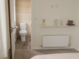 A bathroom with a toilet and shelf at Hazelwood 3, Pinewood Retreat in Rousdon near Lyme Regis
