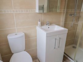 A bathroom with a shower, sink, toilet and towel rack at Hazelwood 3, Pinewood Retreat in Rousdon near Lyme Regis