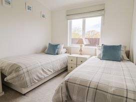 A bedroom with two single beds and a window at Hazelwood 3, Pinewood Retreat in Rousdon near Lyme Regis