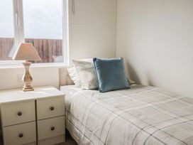 A bedroom with a bed and a lamp at Hazelwood 3 in Pinewood Retreat in Rousdon near Lyme Regis