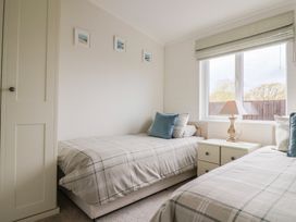 A bedroom with two beds and a bedside table at Hazelwood 3 Pinewood Retreat in Rousdon near Lyme Regis