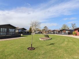 An outdoor area with holiday homes and landscaping at Hazelwood 3 Pinewood Retreat in Rousdon near Lyme Regis