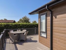 A deck area with a table and chairs at Hazelwood 3 Pinewood Retreat in Rousdon near Lyme Regis