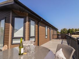 A terrace with a table and glasses at Hazelwood 3 Pinewood Retreat in Rousdon near Lyme Regis