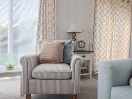 A living room with an armchair and a side table at Hazelwood 3 Pinewood Retreat in Rousdon near Lyme Regis
