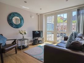 A living room with a sofa and television at Beck House in Weymouth