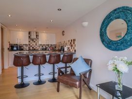 A kitchen with bar stools and a floral arrangement at Beck House in Weymouth