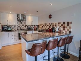 A kitchen with a counter and stools at Beck House in Weymouth