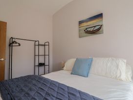 A bedroom with a bed and clothes rack at Beck House in Weymouth