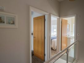 A hallway with multiple doors and a decorative frame at Beck House in Weymouth