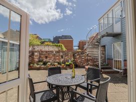 A courtyard with a table and chairs at Beck House in Weymouth