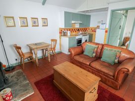 A living room with a sofa and dining area at Warbler Cottage in Cowbridge