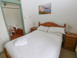A bedroom with a bed and adjoining bathroom at Warbler Cottage in Cowbridge