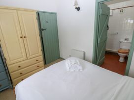 A bedroom with a bed and wardrobe at Warbler Cottage in Cowbridge