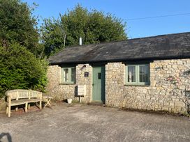 A cottage with a door and windows near a pathway at Warbler Cottage near Cowbridge