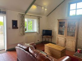 A living room with a sofa and a television at Warbler Cottage near Cowbridge