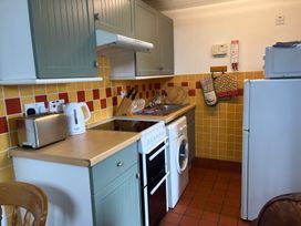 A kitchen with a cooker and washing machine at Warbler Cottage near Cowbridge