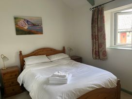 A bedroom with a bed and bedside table at Warbler Cottage near Cowbridge