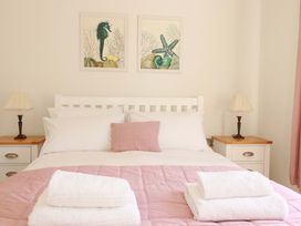 A bedroom with a bed and wall art at Serfaus in Perranporth