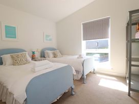 A bedroom with two beds and a window at Serfaus in Perranporth