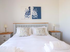 A bedroom with a bed and decorative pillows at Serfaus in Perranporth