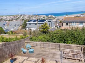 A garden with outdoor furniture and a view of the sea at Serfaus in Perranporth