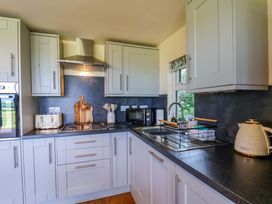 A kitchen with cabinets, sink, stove, and kitchen appliances at Freedom Lodge @ Summerfield Farm in Whitby