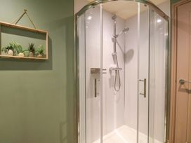 A shower with glass doors in a bathroom at Freedom Lodge @ Summerfield Farm, Whitby