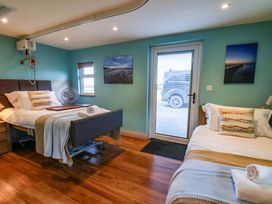 A bedroom with two beds and a door at Freedom Lodge @ Summerfield Farm in Whitby