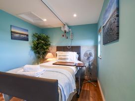 A bedroom with a bed and fan at Freedom Lodge @ Summerfield Farm in Whitby