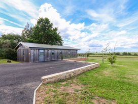 A modern building with a parking area and grass at Freedom Lodge @ Summerfield Farm, Whitby