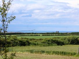 A view of the ocean and fields from a distance at Freedom Lodge @ Summerfield Farm Whitby