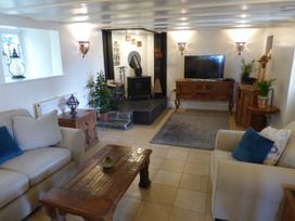 A living room with a television and a fireplace at Trelake Cottage 