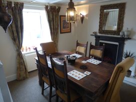 A dining room with a table and chairs at Trelake Cottage