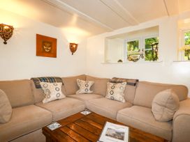 A living room with a sofa and coffee table at Trelake Cottage in Tintagel