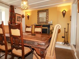 A dining room with a wooden table and chairs at Trelake Cottage in Tintagel