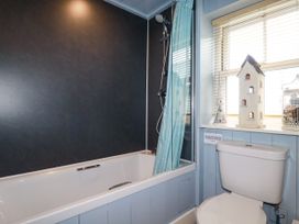 A bathroom with a bathtub, shower, and toilet at Trelake Cottage in Tintagel