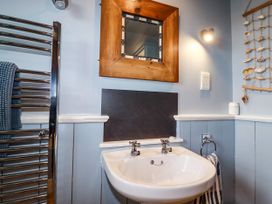 A bathroom with a sink and mirror at Trelake Cottage in Tintagel