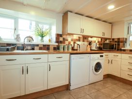 A kitchen with a sink and appliances at Trelake Cottage in Tintagel