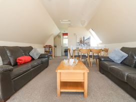 A living room with sofas and dining table at Honeycombe Lodge