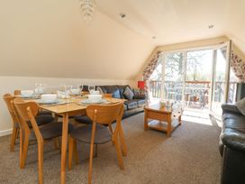A living room with a dining table and chairs at Honeycombe Lodge