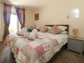 A bedroom with a bed and bedside table at Honeycombe Lodge