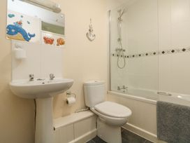 A bathroom with a sink, toilet, and bathtub at Honeycombe Lodge