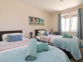 A bedroom with two beds and a desk at Honeycombe Lodge 