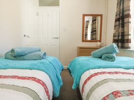A bedroom with two beds and towels arranged at Honeycombe Lodge