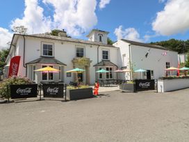 An outdoor seating area with tables and umbrellas at Honeycombe Lodge