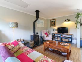 A living room with a stove and television at The Annexe @ Shotley Cottage in Shotley Gate